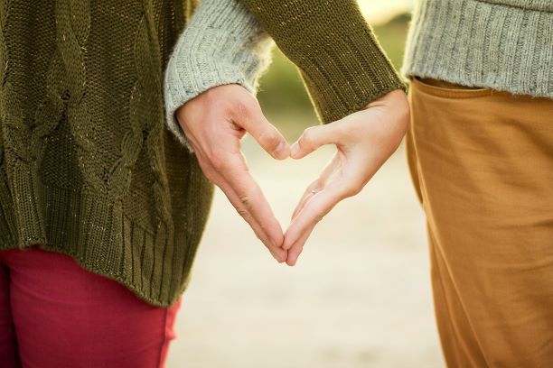 Couple forming heart with hands